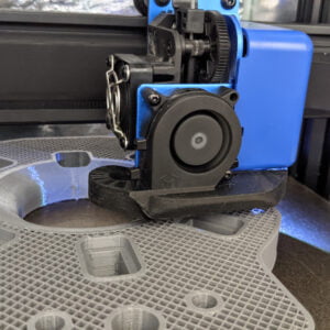 A blue 3D printer while printing a part.